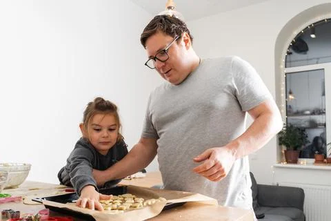 Cropped view of unrecognizable man and his daughter making sweets with biscuit Stock Photos