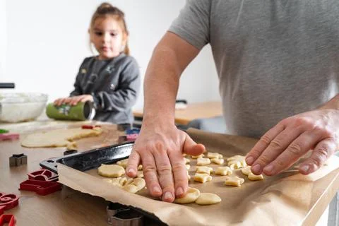Cropped view of unrecognizable man and his daughter making sweets with biscuit Stock Photos