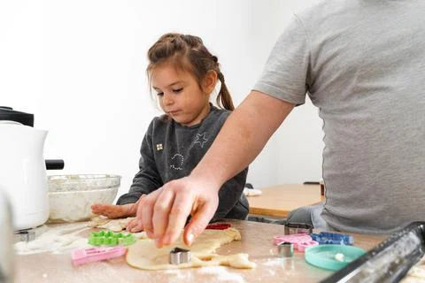 Cropped view of unrecognizable man and his daughter making sweets with biscuit Stock Photos