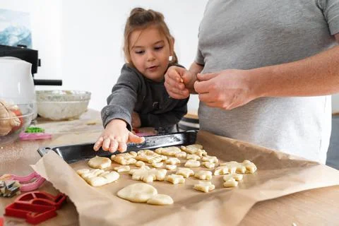 Cropped view of unrecognizable man and his daughter making sweets with biscuit Stock Photos