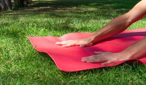 Cropped view of unrecognizable man practicing yoga on the grass. Wellness and Stock Photos