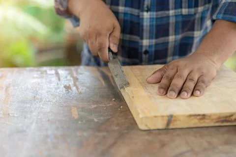 Cropped view of woodworker holding chisel wood. Stock Photos