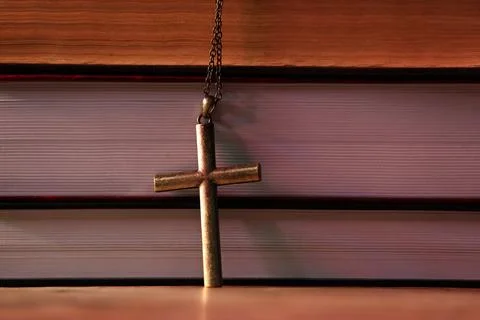 Cross and stack of books on table, closeup. Religion of Christianity Stock Photos