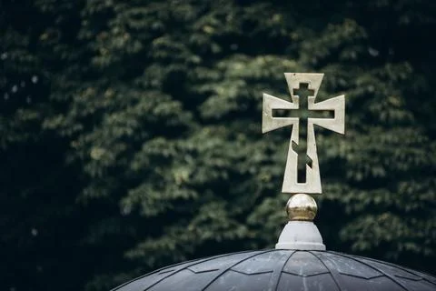 Cross on a background of green branches Stock Photos