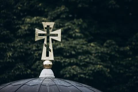 Cross on a background of green branches Stock Photos