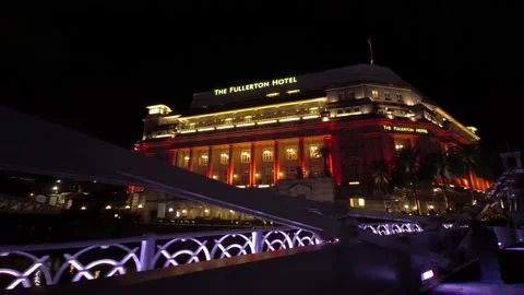 Cross cavenagh bridge facing fullerton hotel night slow walk Stock Footage 138102878