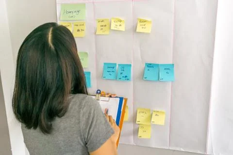 Cross checking data in chart with information on sticky note Stock Photos