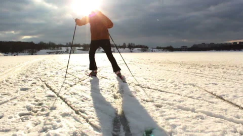 Cross-country skiing on a flat surface of a pond on a warm day Stock Footage 46486520