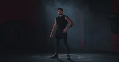 In a cross fit class great looking man in a black sportswear looking straight to Stock Footage 116899919