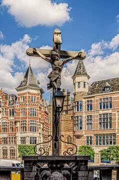Cross in the foreground and background old buildings. Antwerp Belgium. Stock Photos