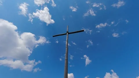 A cross in front of a blue and cloudy sky timelapse 4k 30fps video Stock Footage 243315098