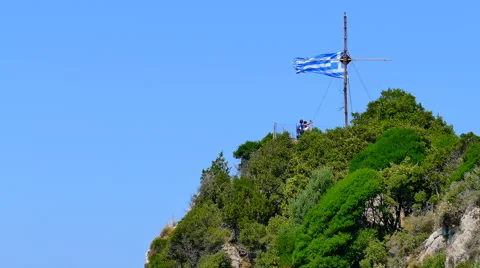 Cross Greece flag wind moving mountain top peak. Corfu, Kanoni HD travel video. Stock Footage 66623370