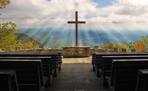 Cross with mountain background and sunrays Stock Photos