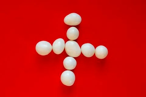 Cross or plus of white pebbles Stock Photos