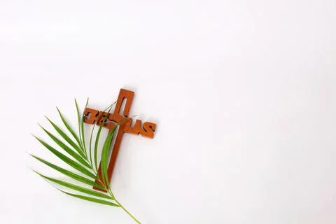 Cross with palm leaf on plain white background Stock Photos