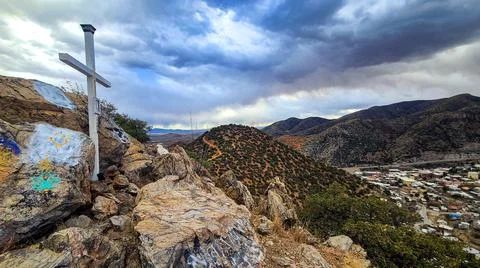 Cross Placed Over Small Mountain Town Foto stock