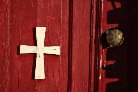 Cross on a red door Stock Photos