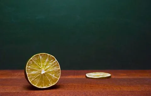 Cross Section Of A Lime And A Lime Slice On A Wooden Table. Green Background. Stock Photos