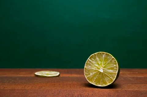 Cross Section Of A Lime And A Lime Slice On A Wooden Table. Green Background. Stock Photos
