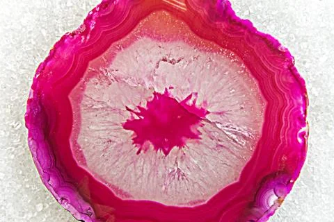 Cross-section of pink agate crystal and sugar crystals in background, macroph Foto stock