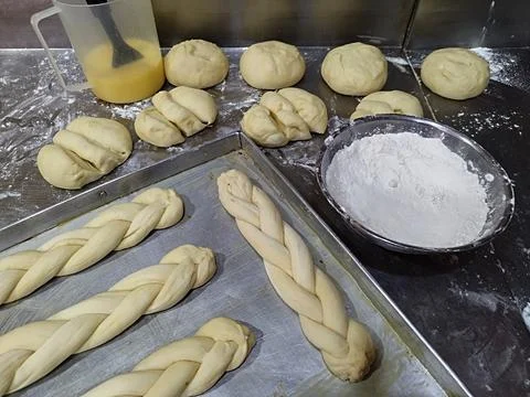 Cross-shaped bread dough arranged in a tray Stock Photos
