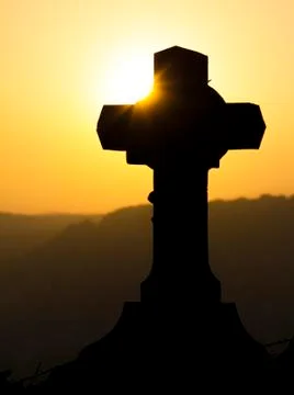 Cross silhouette against a sunset Stockfoto's