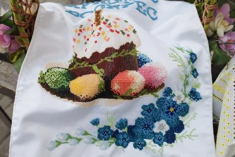 Cross stitched Easter bread and colorful eggs on white cloth napkin Stock Photos