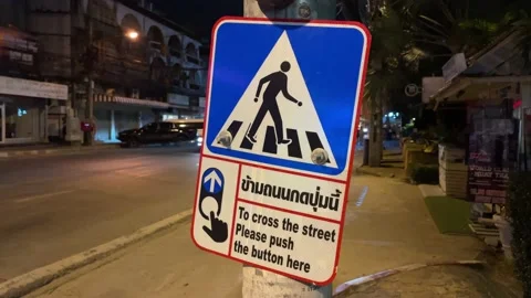 "To cross the street please push the button here" sign on roadside, Thailand Video stock 234643819