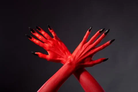 Crossed red devil hands with black nails Fotos de archivo