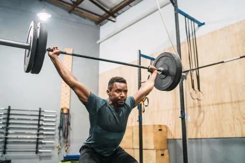 Crossfit athlete doing exercise with a barbell. Stock Photos