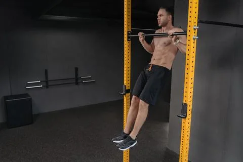 Crossfit athlete doing pull ups at gym Stock Photos
