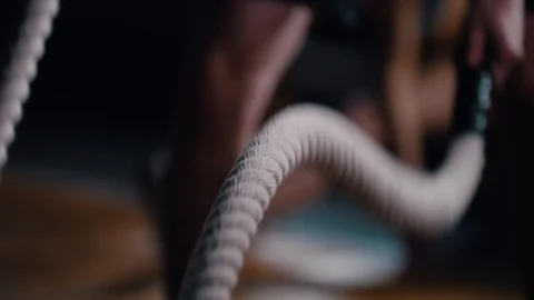 Crossfit. An athletic man training his hands with ropes hitting on the floor Stock Footage 106987578