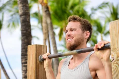 Crossfit man working out pull-ups on chin-up bar Stock Photos