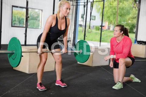 Crossfit woman lifts weights with personal trainer Stock Photos