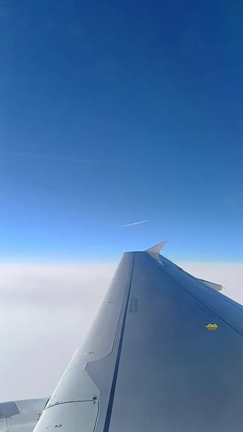 Crossing airplane window view in blue cloudy sky Stock Footage 282010722