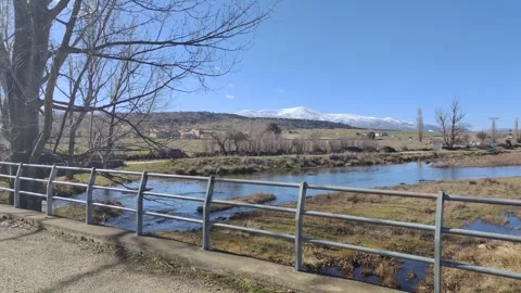 Crossing bridge over river with snowy mountains view Stock Footage 340326213