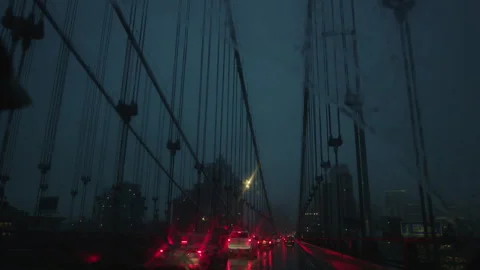 Crossing the brooklyn bridge as red break lights reflect off rain 스톡 동영상 251227819
