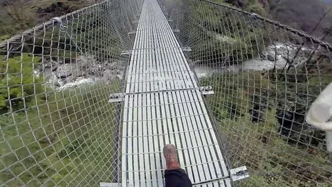 Crossing Himalayan suspension bridge Stock Footage 70609774