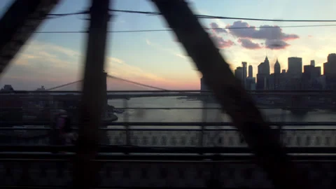 Crossing Manhattan Bridge on the Q train, sunset view over downtown New York Stock Footage 137985032