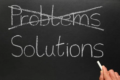 Crossing out problems and writing solutions on a blackboard. Stock Photos