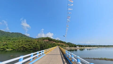 Crossing a River Bridge with a Scenic View of Mountains and Clouds Stock Footage 336691852