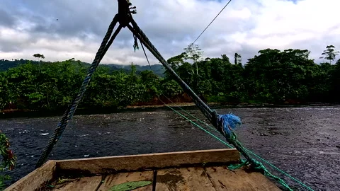 Crossing a tropical river with a handmade small wooden platform Видео 336933769