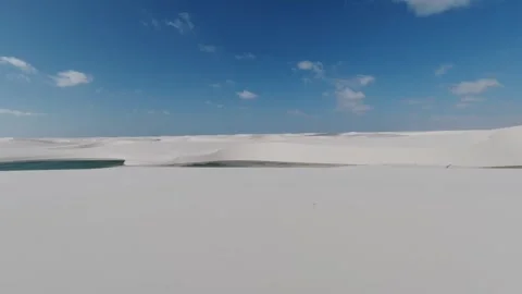 Crossing White Dunes Toward a Green Lagoon at Lençóis Maranhenses Stock Footage 342445100