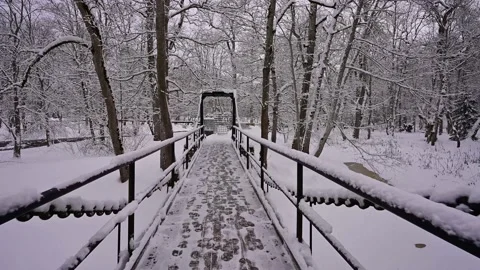 Crossing a winter river through a snowy suspension bridge with strong chains. Stock Footage 236313246