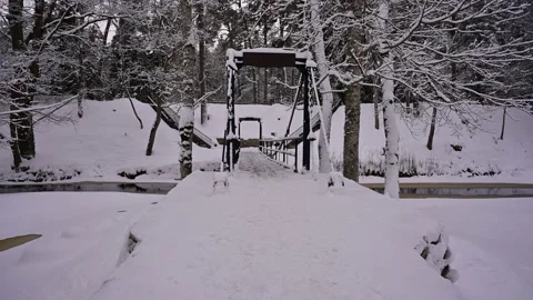 Crossing a winter river through a snowy suspension bridge with strong chains. Stock Footage 236313273