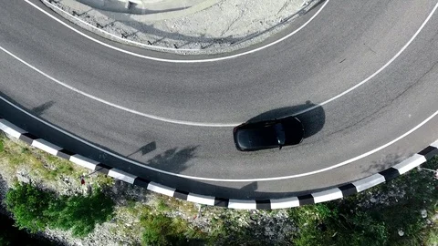 The crossover car is passing a sharp turn of the streamer. Top view 4K Stock Footage 89367454