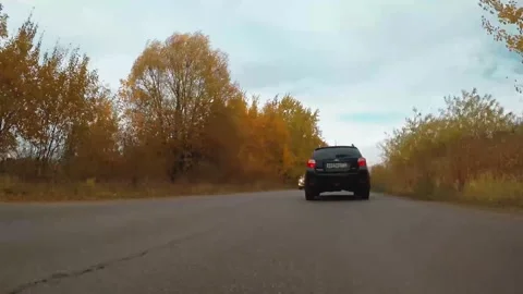 Crossover driving down the autumn road 스톡 동영상 163924506