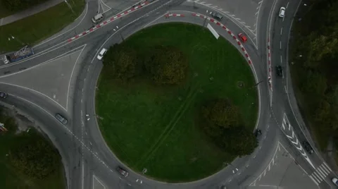 Crossroad roundabout traffic circle clockwise car aerial Stock Footage