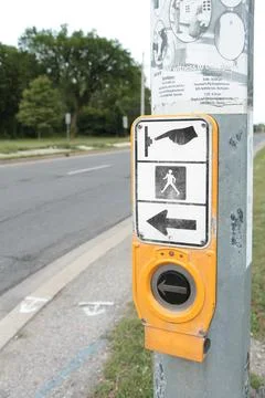 Crosswalk button large black silver circle yellow with illustration above Stock Photos