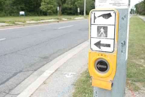 Crosswalk button large black silver circle yellow with illustration above Stock Photos